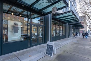 a sidewalk sign in front of a coffee shop on a city street